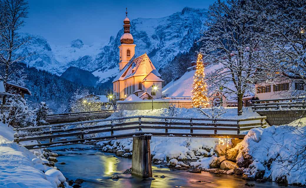 Beautiful twilight view of Sankt Sebastian pilgrimage church with decorated Christmas tree illuminated during blue hour at dusk in winter, Ramsau, Germany