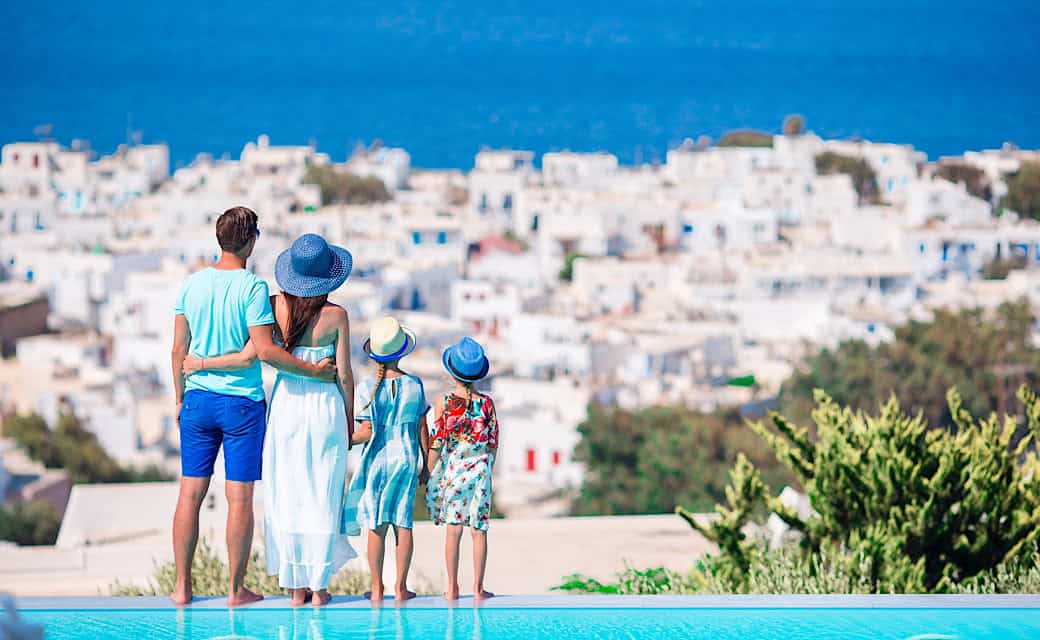 Family of four on European vacation on the edge of pool, family friendly luxury vacation.